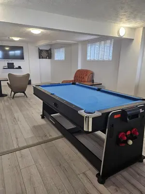 a pool table in a living room with a table at Stunning Front Line Ocean Views Luxury Beach House in Downderry