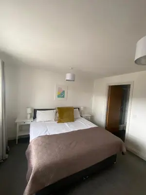 a bedroom with a large white bed with two pillows at Bredon Court overlooking Fistral beach, Newquay in Newquay