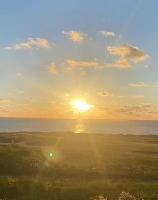 a sunset over the ocean with the sun in the sky at Bredon Court overlooking Fistral beach, Newquay in Newquay
