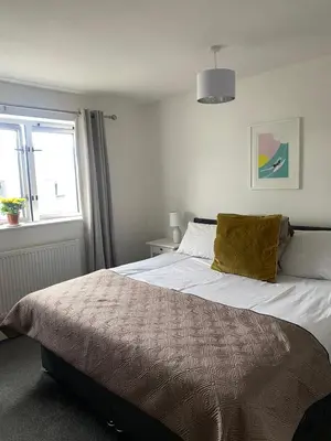 a bedroom with a bed and a window at Bredon Court overlooking Fistral beach, Newquay in Newquay