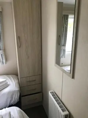 a room with a bedroom with a mirror and a bed at 2 Bedroom Caravan. Newquay. Cornwall. in Newquay