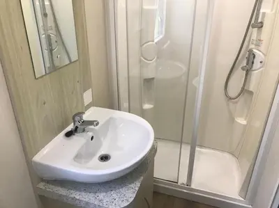 a bathroom with a white sink and a shower at 2 Bedroom Caravan. Newquay. Cornwall. in Newquay