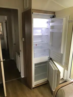 an empty refrigerator with its door open in a room at 2 Bedroom Caravan. Newquay. Cornwall. in Newquay