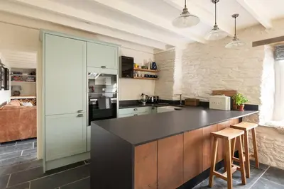 a kitchen with a black counter top in a room at White House, Port Isaac Bay Holidays in Port Isaac