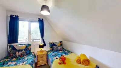 a bedroom with two beds and a window at 45 Trevithick Court, Tolroy Manor in Hayle