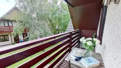 a balcony with a table with a book and a vase of flowers at 45 Trevithick Court, Tolroy Manor in Hayle