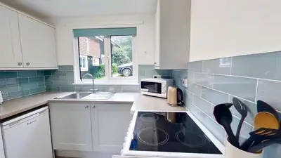a kitchen with a sink and a microwave at 46 Strawberry Hill, Tolroy Manor in Hayle