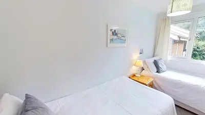 a white living room with a couch and a window at 46 Strawberry Hill, Tolroy Manor in Hayle