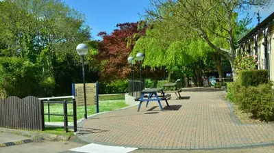 a picnic table on a brick sidewalk next to a building at 46 Strawberry Hill, Tolroy Manor in Hayle