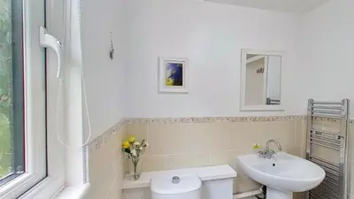 a white bathroom with a sink and a toilet at 46 Strawberry Hill, Tolroy Manor in Hayle