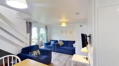a living room with a blue couch and a table at 46 Strawberry Hill, Tolroy Manor in Hayle