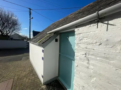 a building with a blue door on the side of it at Cilia Marys Annexe St Teath in Saint Teath