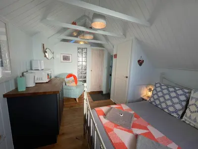 a small bedroom with a bed and a kitchen at Cilia Marys Annexe St Teath in Saint Teath