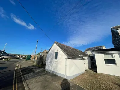 a white building on the side of a street at Cilia Marys Annexe St Teath in Saint Teath