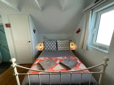 a small bedroom with a bed in a attic at Cilia Marys Annexe St Teath in Saint Teath