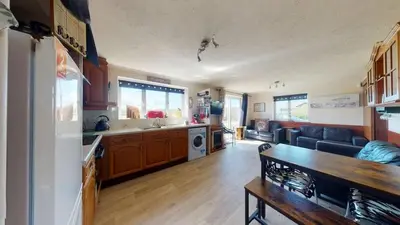 a kitchen and living room with a couch and a table at D53 Bide A Wee, Riviere Towans in Hayle
