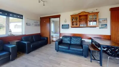 a living room with a couch and a table and chairs at D53 Bide A Wee, Riviere Towans in Hayle