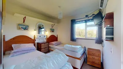 a bedroom with two beds and a window at D54 Wheal Shoat, Riviere Towans in Hayle