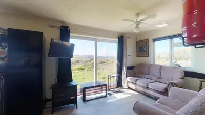 a living room with a couch and a fireplace at D54 Wheal Shoat, Riviere Towans in Hayle