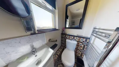 a bathroom with a sink and a toilet and a mirror at D54 Wheal Shoat, Riviere Towans in Hayle
