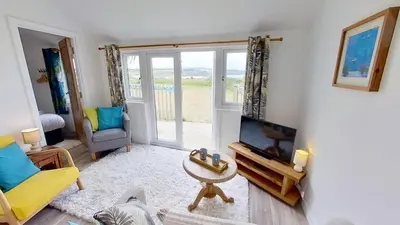 a living room with a flat screen tv and a couch at A17 Placerville, Riviere Towans in Hayle