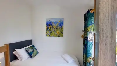 a room with a bed and a painting on the wall at A17 Placerville, Riviere Towans in Hayle