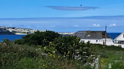 a house on a hill with a view of the ocean at A17 Placerville, Riviere Towans in Hayle
