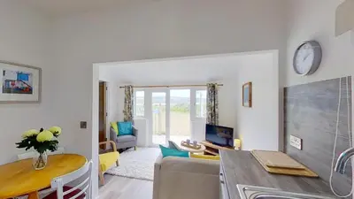 a living room with a couch and a table at A17 Placerville, Riviere Towans in Hayle