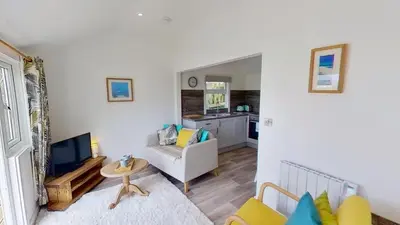 a living room with a couch and a tv at A17 Placerville, Riviere Towans in Hayle
