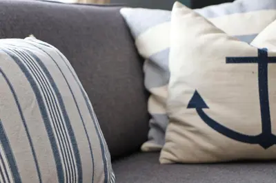 a pillow with an arrow on it sitting on a couch at Holiday lodge, on-site watersports, Retallack Resort in Saint Columb Major