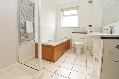 a bathroom with a tub and a toilet and a sink at Holiday lodge, on-site watersports, Retallack Resort in Saint Columb Major