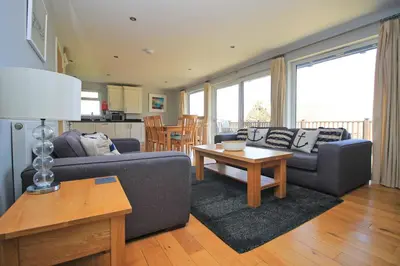 a living room with two couches and a table at Holiday lodge, on-site watersports, Retallack Resort in Saint Columb Major