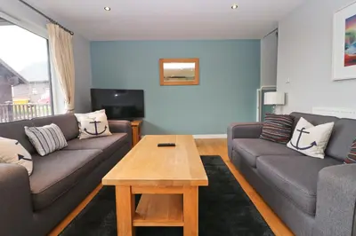 a living room with two couches and a coffee table at Holiday lodge, on-site watersports, Retallack Resort in Saint Columb Major