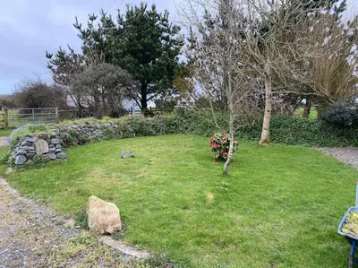 a garden with a bunch of flowers in the grass at Idyllic Cornish Retreat At Puffin Lodge in Helston