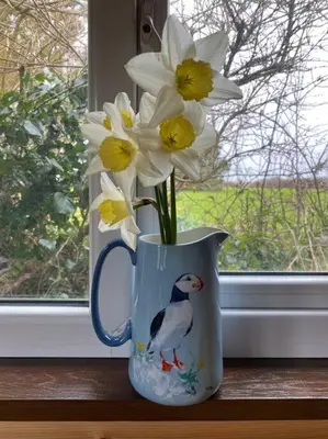 a vase filled with white and yellow flowers in a window at Idyllic Cornish Retreat At Puffin Lodge in Helston