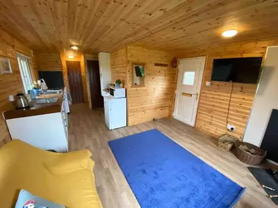 a living room with a blue rug in a cabin at Idyllic Cornish Retreat At Puffin Lodge in Helston