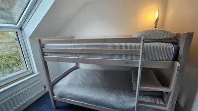 a bunk bed in a room next to a window at Driftwood in Porthtowan