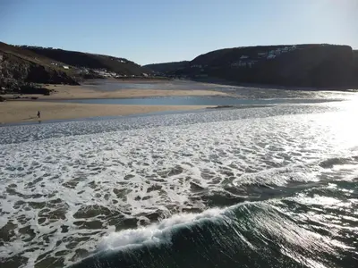 an aerial view of a beach with waves at Driftwood in Porthtowan