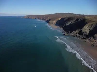 an aerial view of the ocean and a beach at Driftwood in Porthtowan