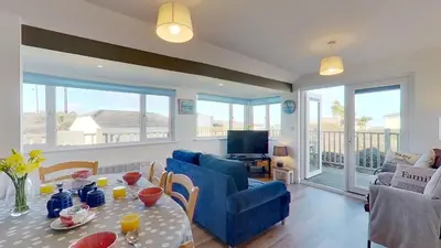a living room with a blue couch and a table at F08 Carne Michael, Riviere Towans in Hayle