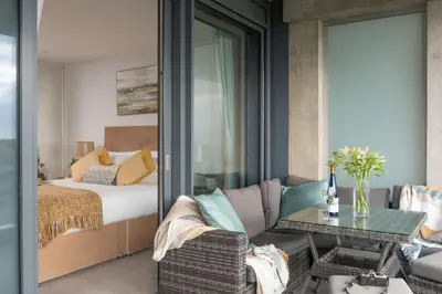 a bedroom with a bed and a couch and a table at Oceans Eleven - Sea view - Secure parking - Footsteps from beach in Falmouth
