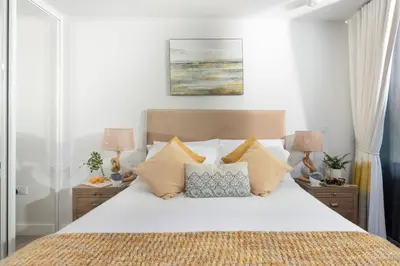 a bedroom with a large white bed with pillows at Oceans Eleven - Sea view - Secure parking - Footsteps from beach in Falmouth