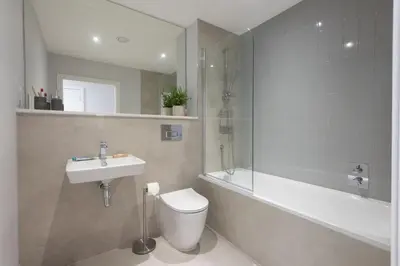 a bathroom with a toilet and a sink and a shower at Oceans Eleven - Sea view - Secure parking - Footsteps from beach in Falmouth