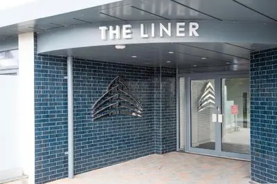 a blue tiled building with a sign that reads the liner at Oceans Eleven - Sea view - Secure parking - Footsteps from beach in Falmouth