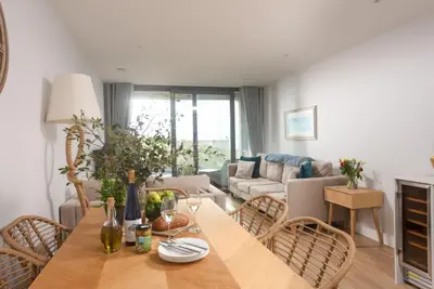 a living room with a wooden table and chairs at Oceans Eleven - Sea view - Secure parking - Footsteps from beach in Falmouth