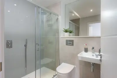 a bathroom with a shower and a toilet and a sink at Oceans Eleven - Sea view - Secure parking - Footsteps from beach in Falmouth