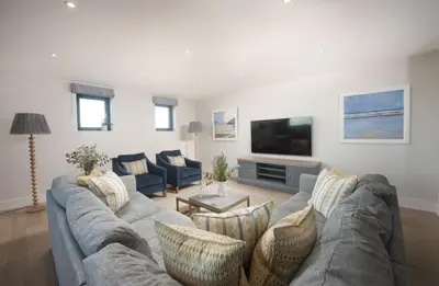 a living room with a couch and a tv at Harlyn Penthouse, Harlyn Bay - 1 pet accepted - Free Wi-fi - Sea View in St Merryn