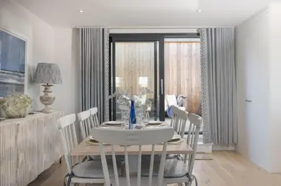 a dining room with a wooden table and chairs at Harlyn Penthouse, Harlyn Bay - 1 pet accepted - Free Wi-fi - Sea View in St Merryn