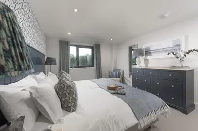 a bedroom with a large white bed and a dresser at Harlyn Penthouse, Harlyn Bay - 1 pet accepted - Free Wi-fi - Sea View in St Merryn