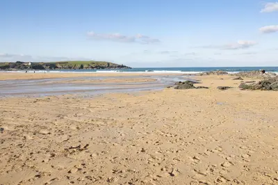 a sandy beach with footprints in the sand at Harlyn Penthouse, Harlyn Bay - 1 pet accepted - Free Wi-fi - Sea View in St Merryn